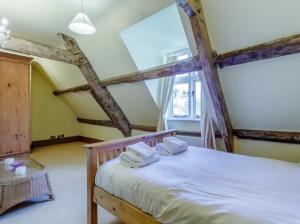a bedroom with a bed with two towels on it at Henrhiw Farm House at Henrhiw Farm Cottages in Usk
