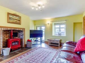 a living room with a couch and a fireplace at Henrhiw Farm House at Henrhiw Farm Cottages in Usk