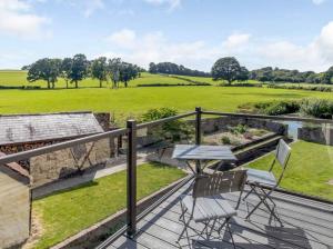 a patio with a table and chairs on a deck at Henrhiw Farm House at Henrhiw Farm Cottages in Usk