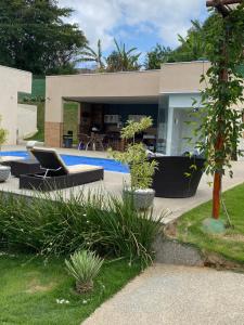 a house with a swimming pool in front of it at Sitio Silveira Nobre - São Joaquim de Bicas in São Joaquim de Bicas