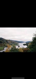 widok na rzekę z drzewami na pierwszym planie w obiekcie Inviting 1-Bed Studio in Pitlochry w mieście Pitlochry