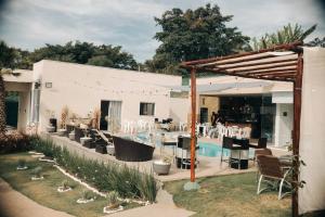 a backyard with a pool and a table and chairs at Sitio Silveira Nobre - São Joaquim de Bicas in São Joaquim de Bicas