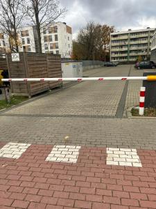 een barrière op een bakstenen straat met gebouwen op de achtergrond bij Hostel 24 Miejsca Parkingowe Noclegi Pracownicze. in Gorzów Wielkopolski