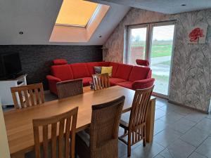 - un salon avec un canapé rouge et une table dans l'établissement Kniepwiekerhof, à Neukamperfehn