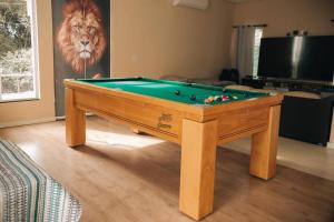 a pool table in a living room with a lion painting at Sitio Silveira Nobre - São Joaquim de Bicas in São Joaquim de Bicas