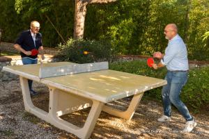 two men playing ping pong on a ping pong table at Appart'Hotel Castel Emeraude, Charme et Caractère in Amélie-les-Bains-Palalda