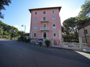 a pink building on the side of a street at Castiglioncello Suite in Castiglioncello