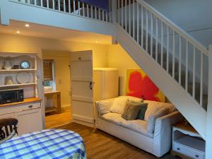 a room with a staircase with a couch under a stair case at Little Barn in Dorchester