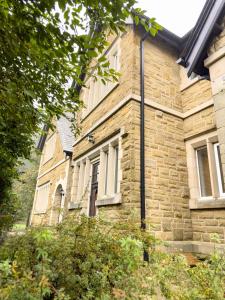 una antigua casa de piedra con ventanas blancas y una puerta en 2 Bed - Close to LBU, Headingley Stadium and YCC en Leeds