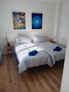 2 letti in una camera da letto con cuscini blu di Apartamento OM con piscina y vistas al mar a Costa Teguise