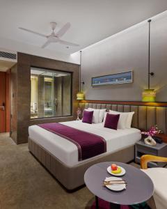 um quarto de hotel com uma cama grande e uma mesa em Moyrah By Greenpark em Anjuna