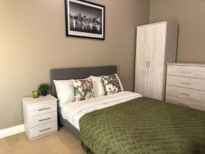 um quarto com uma cama com uma cómoda e um armário em 2 Bed - Close to LBU, Headingley Stadium and YCC em Leeds