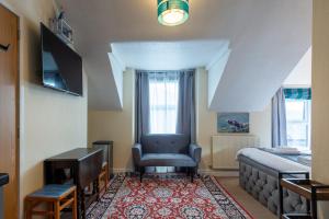1 dormitorio con cama, silla y escritorio en THE AMBLESIDE APARTMENTS - Self catering with private kitchen - Best for Location, en Ambleside