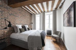 a bedroom with a bed and a brick wall at Ghost in Paris