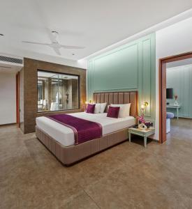 a large bedroom with a large bed with purple pillows at Kamah, Goa in Anjuna +70 photos