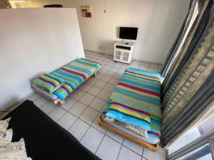 a living room with two beds and a tv at Uvongo Square 2 in Margate