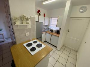 a kitchen with a table with a stove in it at Uvongo Square 2 in Margate