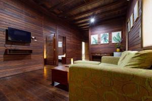 sala de estar con sofá y TV de pantalla plana en RedDoorz Resort @ Taman Wisata Mangrove, en Yakarta