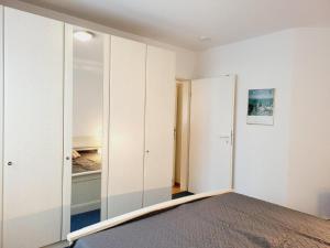 キュールングスボルンにあるAppartementhaus Olympの白い壁のベッドルーム1室、鏡付きのベッド1台が備わります。