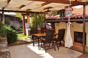 eine Terrasse mit einem Holztisch und Stühlen unter einer Pergola in der Unterkunft Toncevi Eco Estate in Branik