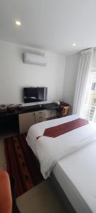 1 dormitorio con cama y escritorio con ventana en مبنى هلال en Amán