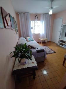 uma sala de estar com um sofá e um vaso de plantas em Hospedagem Domiciliar Alternativa em Balneário Camboriú