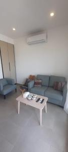 ein Wohnzimmer mit einem blauen Sofa und einem Couchtisch in der Unterkunft مبنى هلال in Amman