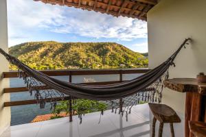 a hammock on a balcony with a view of the water at Pousada Porto de Piranhas in Piranhas