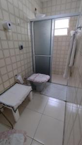 a white bathroom with a shower and a toilet at Hospedagem Domiciliar Alternativa in Balneário Camboriú