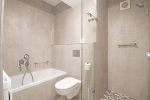 a bathroom with a toilet and a glass shower at 210 Breakers Resort Umhlanga Rocks in Durban +11 photos