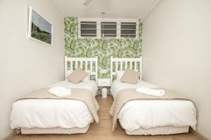 two beds in a room with a green and white wallpaper at 210 Breakers Resort Umhlanga Rocks in Durban