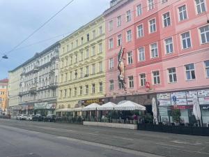 Cosy flat with huge Terrasse! Long or Shortterm في فيينا: صف من المباني الطويلة على شارع المدينة