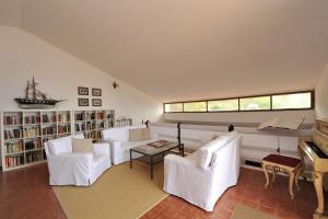 a living room with white chairs and a piano at Villa La Fenice by Wonderful Italy in Castellammare del Golfo