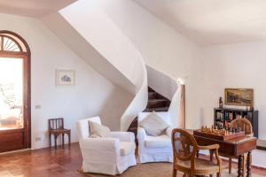 a living room with white furniture and a staircase at Villa La Fenice by Wonderful Italy in Castellammare del Golfo