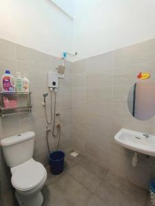 y baño con aseo y lavamanos. en ASFA Homestay Kuching en Kuching