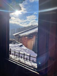 une fenêtre d'une maison avec de la neige au sol dans l'établissement Wohnung gemütlich mit Stil „la tgea cotschna“, à Pignieu