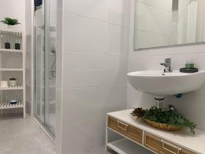 y baño blanco con lavabo y ducha. en Casa Urquinaona, en Cádiz