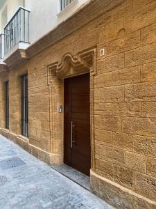 un edificio de ladrillo marrón con puerta de madera en Casa Urquinaona, en Cádiz
