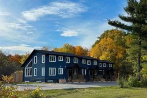 een groot blauw huis met bomen op de achtergrond bij The Cottages at Blue - Cottage 3 in Blue Mountains