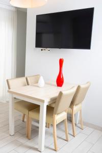 a white dining room table and chairs with a vase on it at Hotel La Ciotat - A deux pas de l'eau in La Ciotat