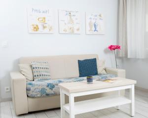 a white living room with a couch and a table at Hotel La Ciotat - A deux pas de l'eau in La Ciotat