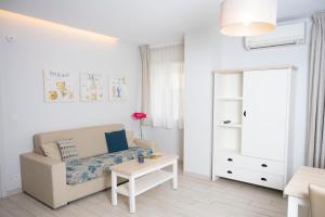 a white living room with a couch and a table at Hotel La Ciotat - A deux pas de l'eau in La Ciotat