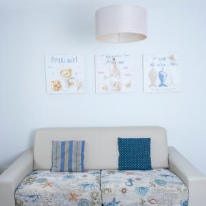 a white couch with blue pillows in a room at Hotel La Ciotat - A deux pas de l'eau in La Ciotat