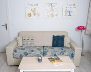 a living room with a couch and a coffee table at Hotel La Ciotat - A deux pas de l'eau in La Ciotat