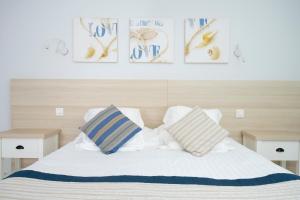 a bedroom with a bed with two pillows on it at Hotel La Ciotat - A deux pas de l'eau in La Ciotat