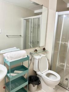 a bathroom with a toilet and a glass shower at Azure North - Munar Suite in Lagundi