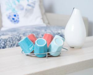 a group of cups sitting on a table next to a bed at Hotel La Ciotat - A deux pas de l'eau in La Ciotat