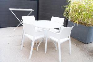 two white chairs and a white table and chairs at Hotel La Ciotat - A deux pas de l'eau in La Ciotat