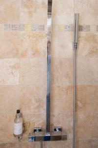 a shower in a bathroom with a bottle of soap at Hotel La Ciotat - A deux pas de l'eau in La Ciotat