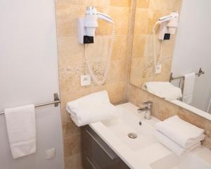 a bathroom with a sink and a mirror at Hotel La Ciotat - A deux pas de l'eau in La Ciotat